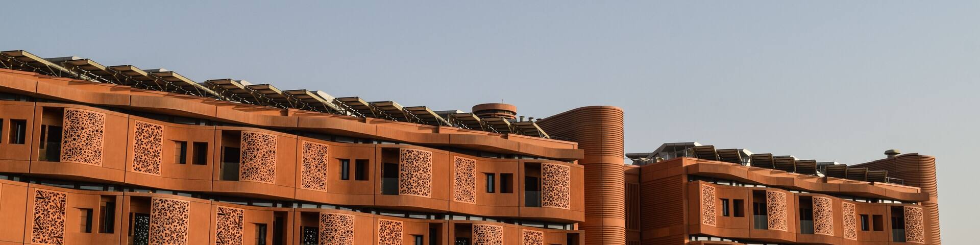 Facade of Masdar Institute Campus, in Masdar City, in contrast with the blue sky. Abu Dhabi, United Arab Emirates.