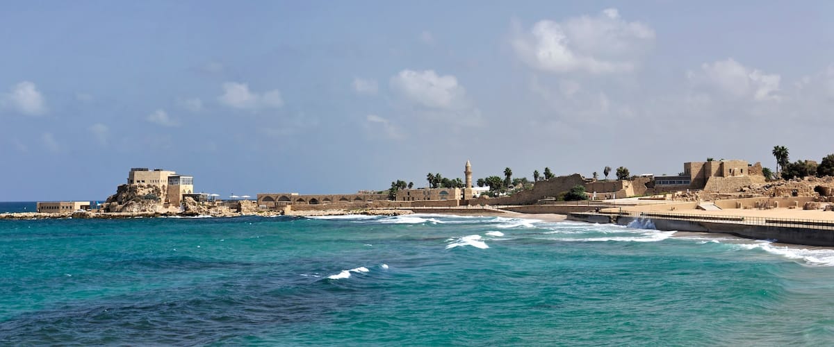 A coastal town with historic buildings and a lighthouse.