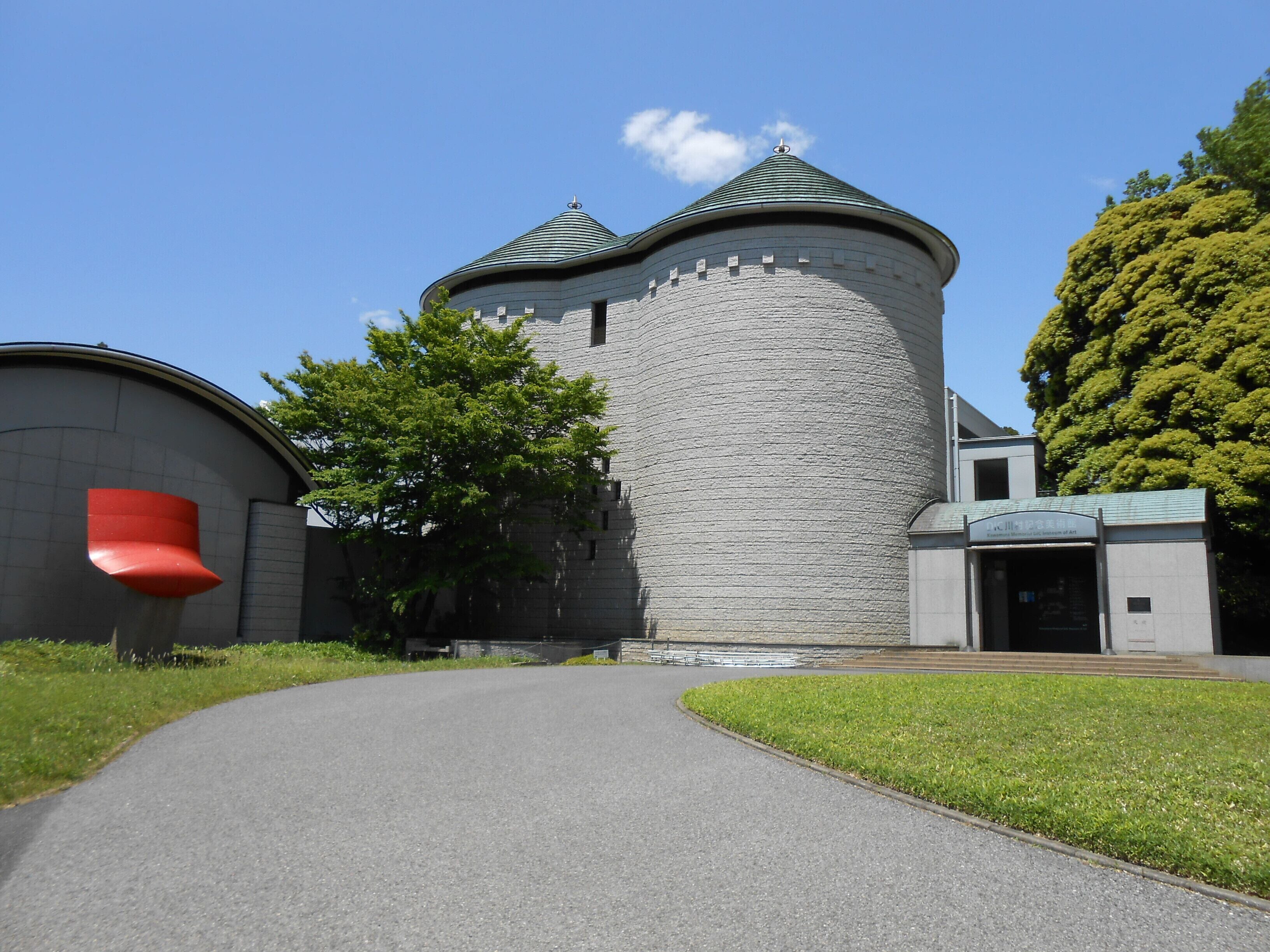 A castle-like building with a turret and a red structure to the left.
