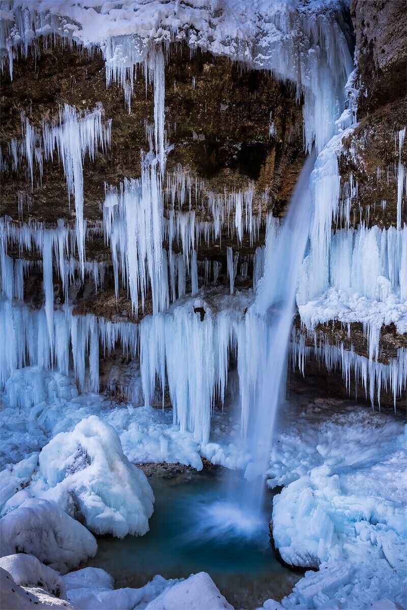 A frozen waterfall with icicles hanging from the cliff.