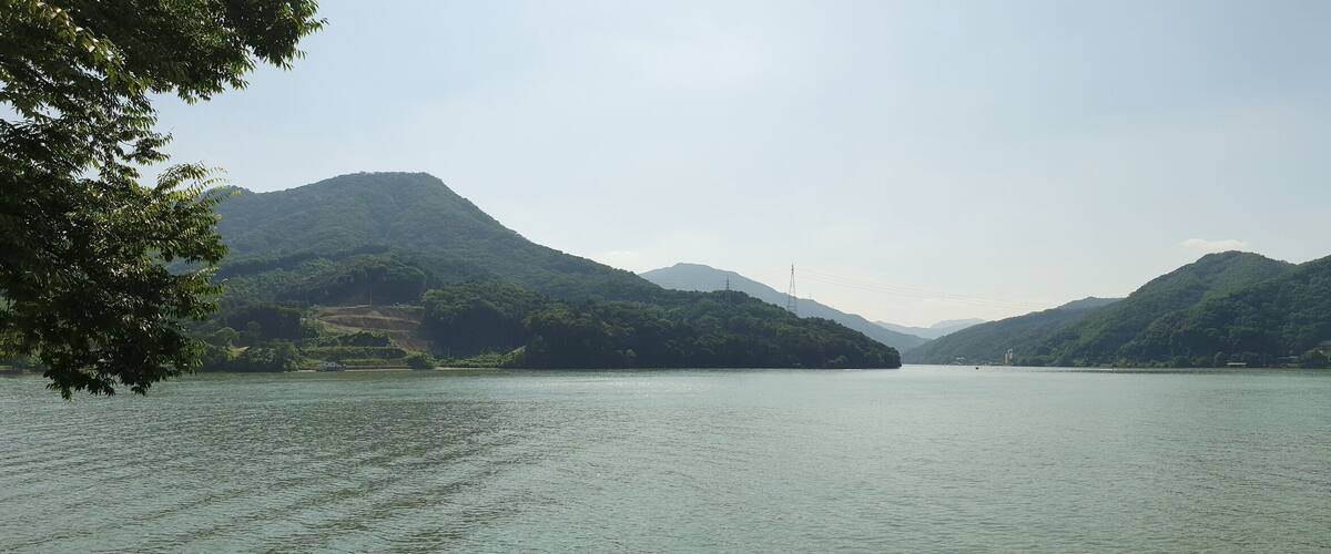 A calm lake surrounded by lush green mountains.