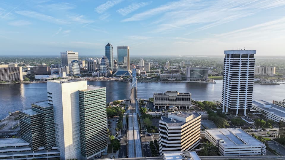 Cityscape view from San Marco and downtown Jacksonville, Florida, on a beautiful blue-sky spring day, with the river, John T. Alsop Jr. Bridge, and tall buildings.