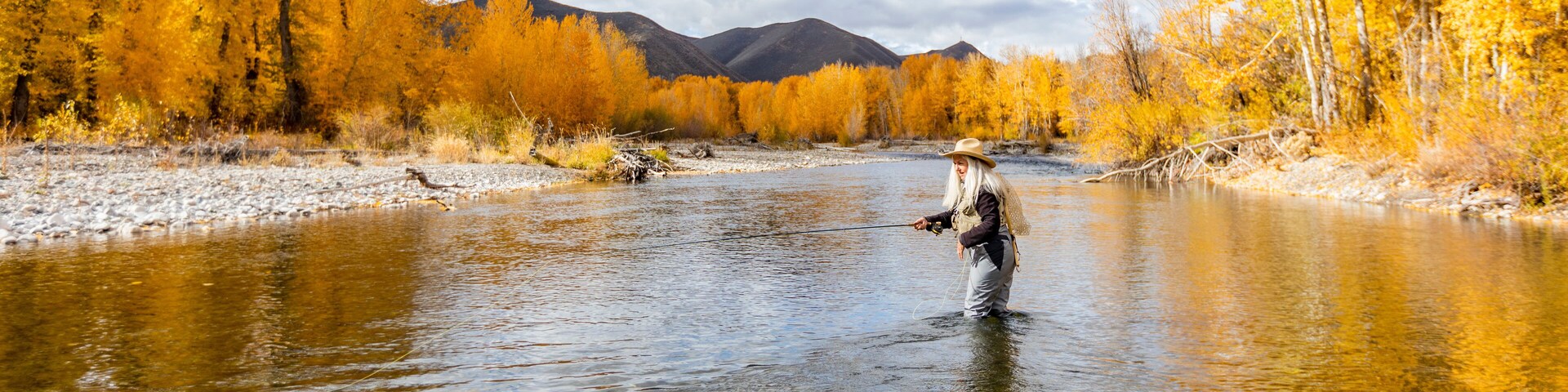 USA, Idaho, Bellevue, Senior woman fly-fishing in Big Wood River in autumn