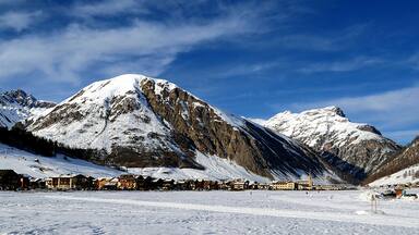 A snow-covered mountain range with a ski resort in the foreground.