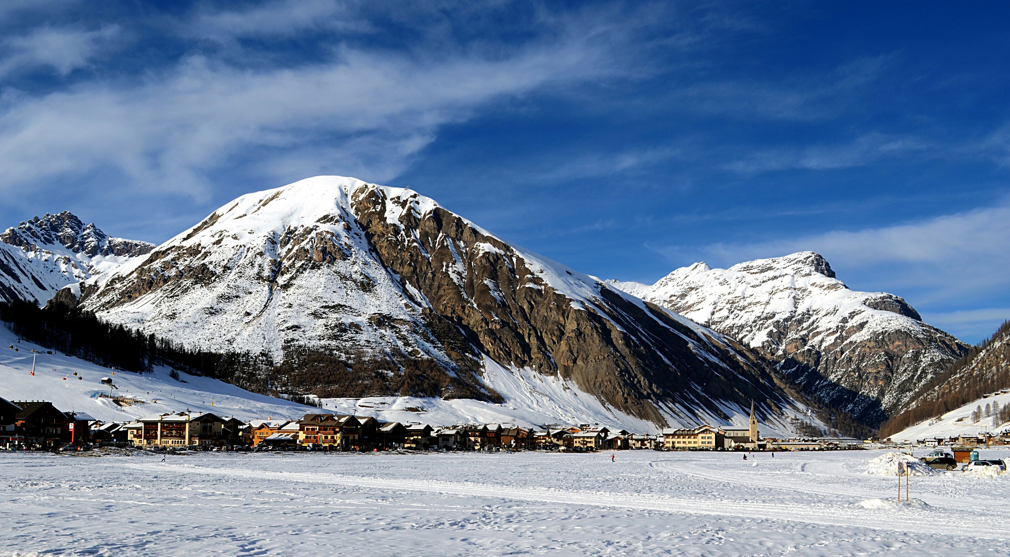 A snow-covered mountain range with a ski resort in the foreground.