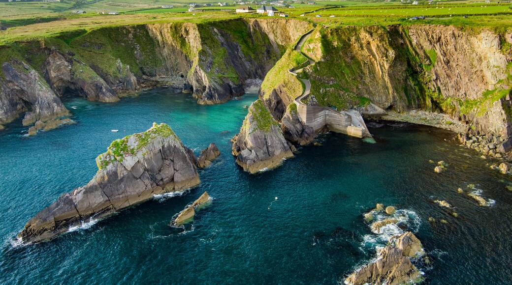 Dunquin or Dun Chaoin pier, Ireland's Sheep Highway. Aerial view of narrow pathway winding down to the pier, ocean coastline, cliffs. Popular location on Slea Head Drive and Wild Atlantic Way.