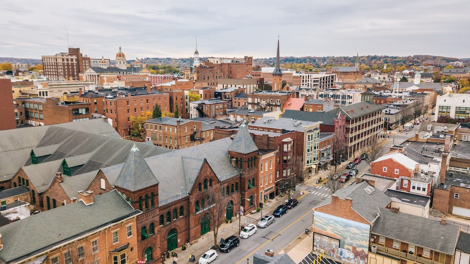 A cityscape with historic buildings, a prominent church steeple, and a mural on a building.