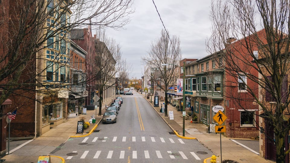 A street lined with brick buildings, a pedestrian crossing, and a yellow fire hydrant.