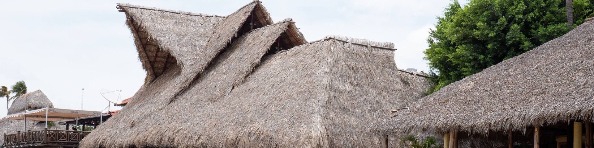 San Juan del Sur, Nicaragua - May 09, 2019: Beach house with straw roof. Travel destination. Touristic place. Tropical straw cafe. Touristic beach with rustic house restaurant. Vacation and travel