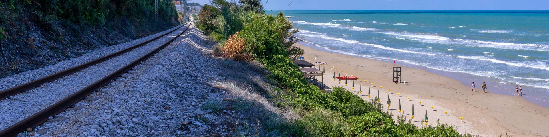 Walking on the beach. Apulia coast: San Menaio Beach in Gargano National Park, Italy. A long golden strip caresses the green sea for more than two kilometres of San Menaio, Apulian fishing village.