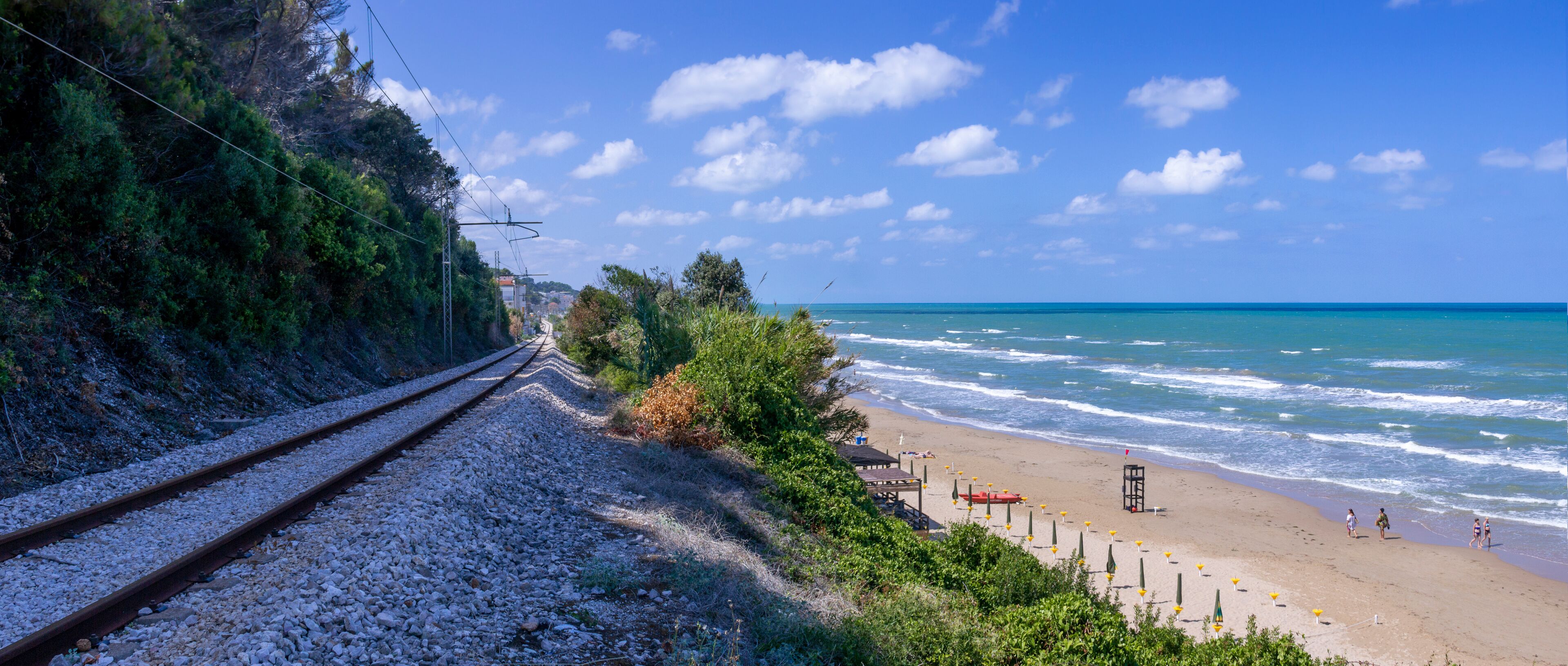 A coastal railway track, beach, and ocean.
