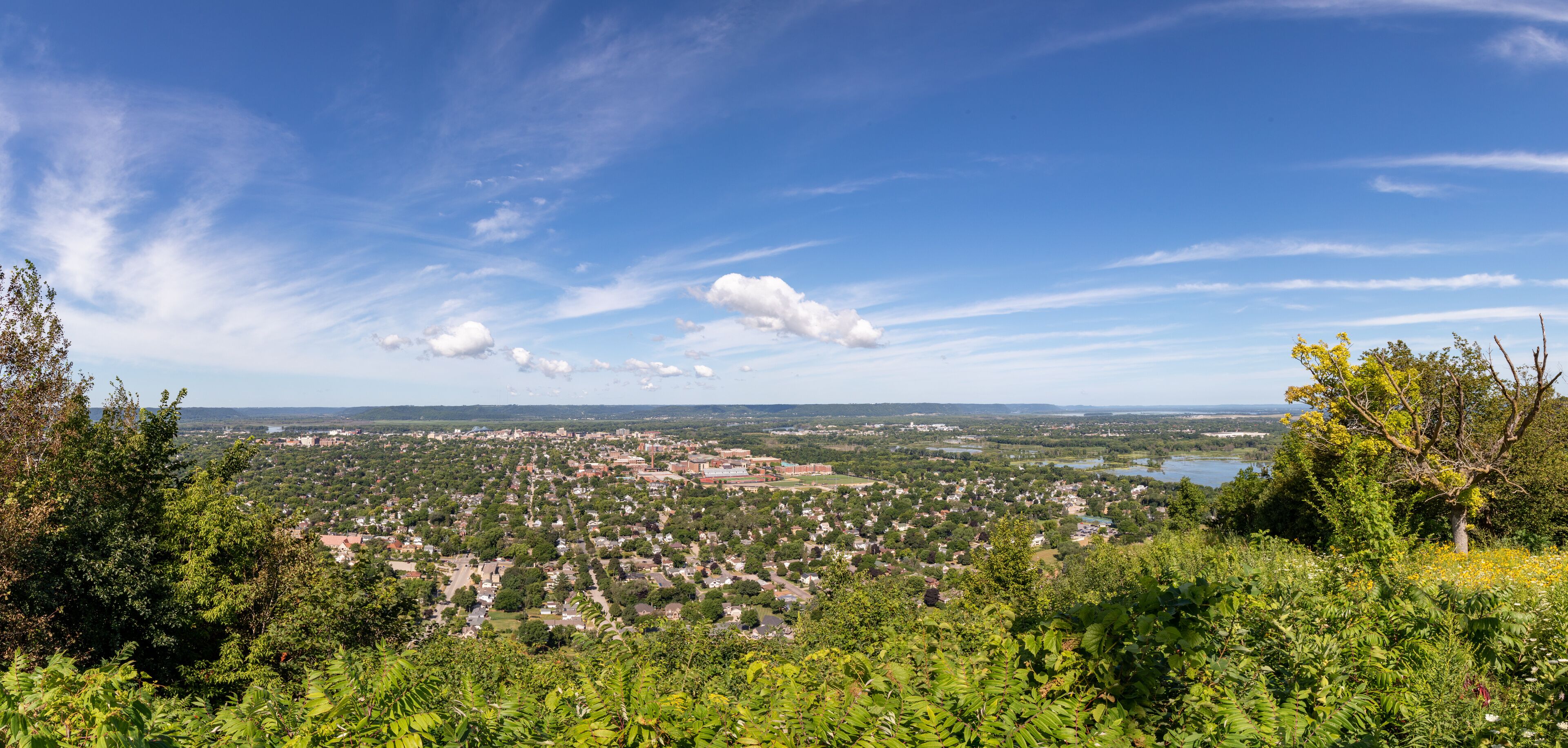 A town surrounded by greenery and a lake.