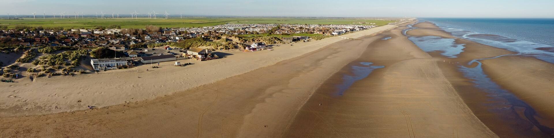 Aerial drone. Camber Sands in East Sussex. Popular seaside destination with large sandy beach and surfing spot in England.