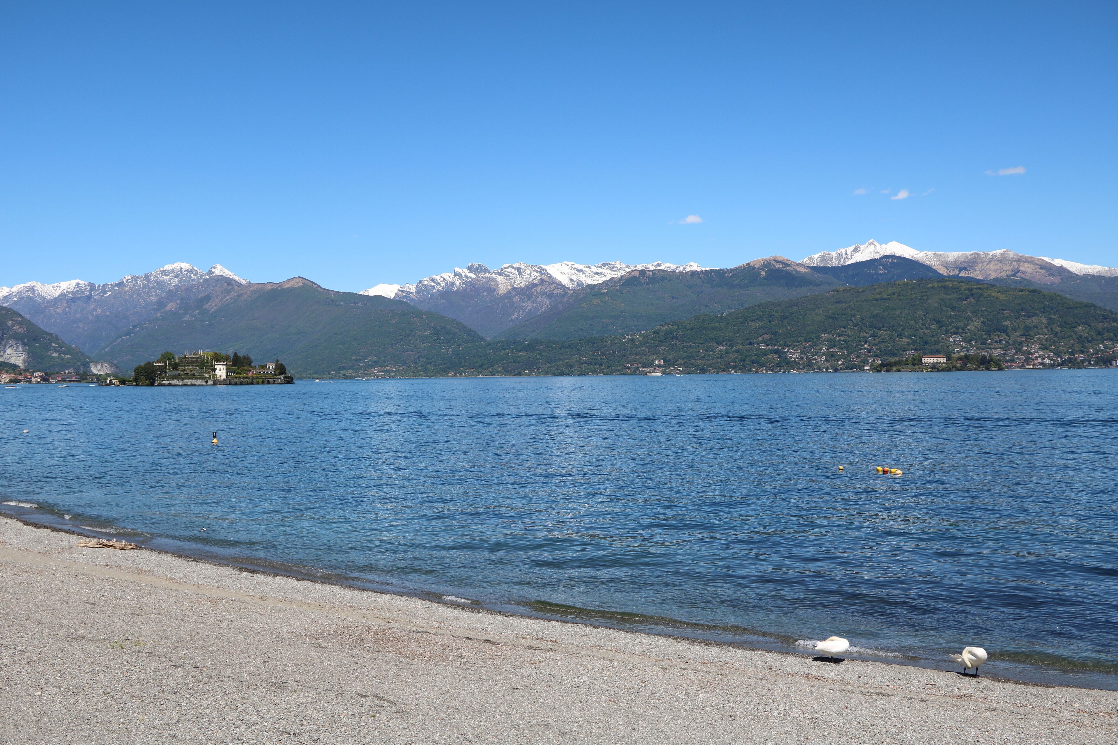 A lake with mountains in the background and a small island with buildings.