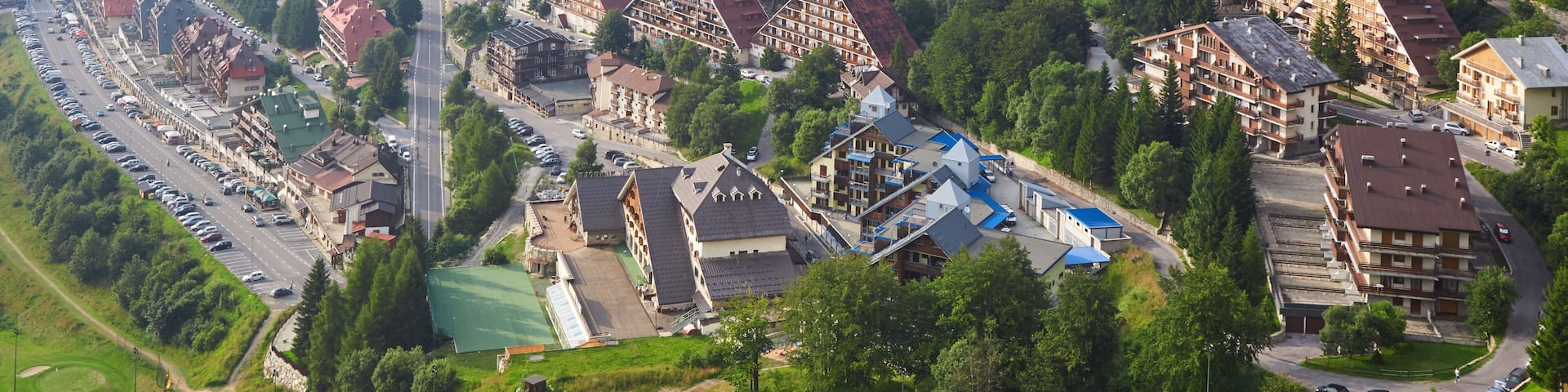 A hillside town with residential buildings, roads, and greenery.