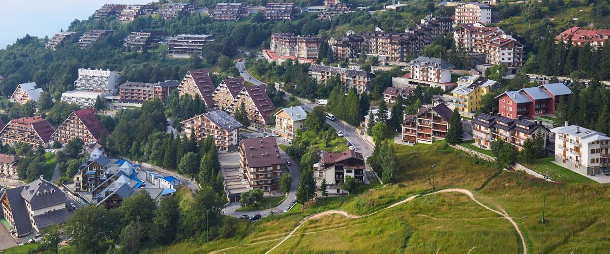 A hillside town with buildings, roads, and greenery.