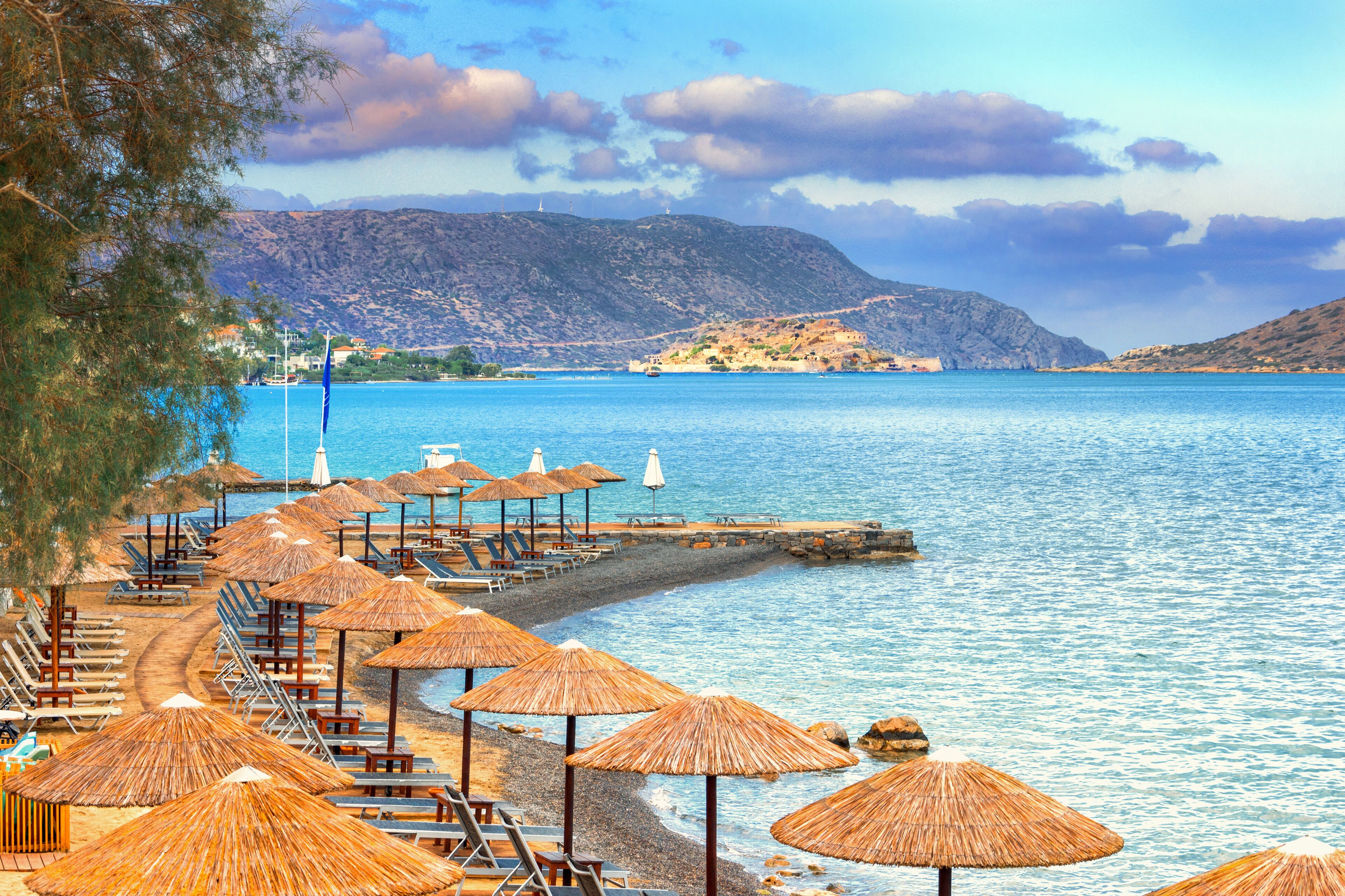 Panoramic view of the gulf of Elounda with the famous village of Elounda and the island of Spinalonga at sunset with nice clouds and calm sea, Crete, Greece.