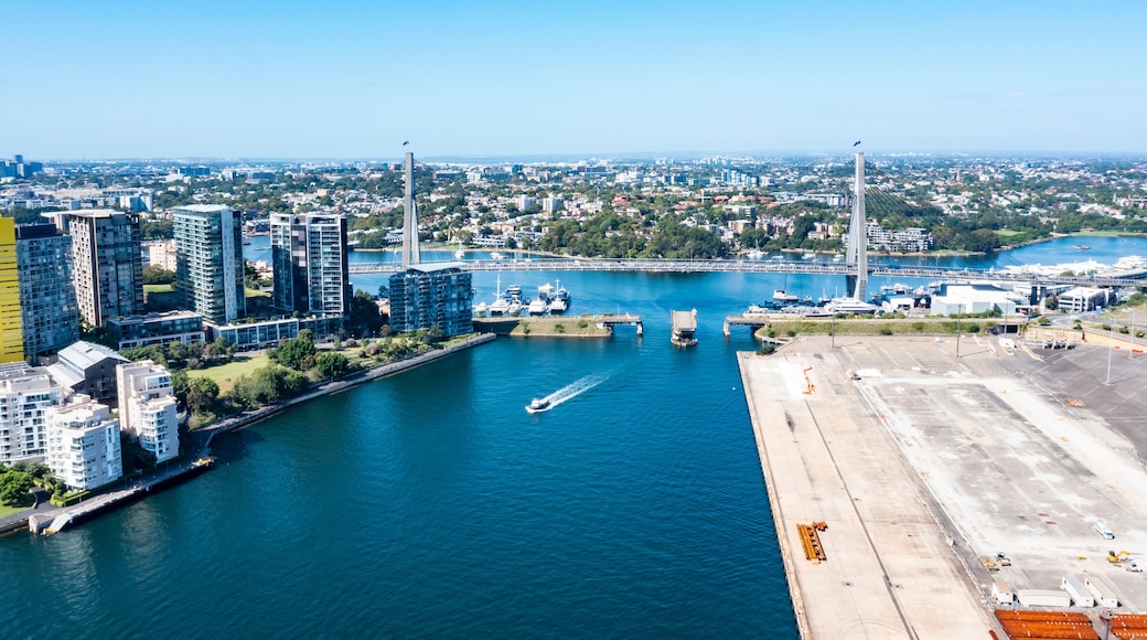 Aerial drone view of Anzac Bridge across Johnstons Bay looking toward Rozelle Bay and Bicentennial Park in Rozelle, Sydney, Australia on a sunny morning