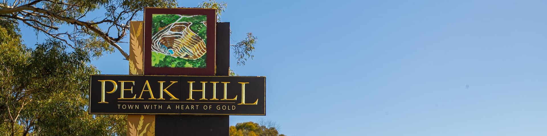 A sign for Peak Hill, Town with a Heart of Gold, and the Parkes Shire logo.