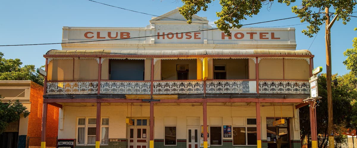 A two-story building with a sign reading "Club House Hotel".
