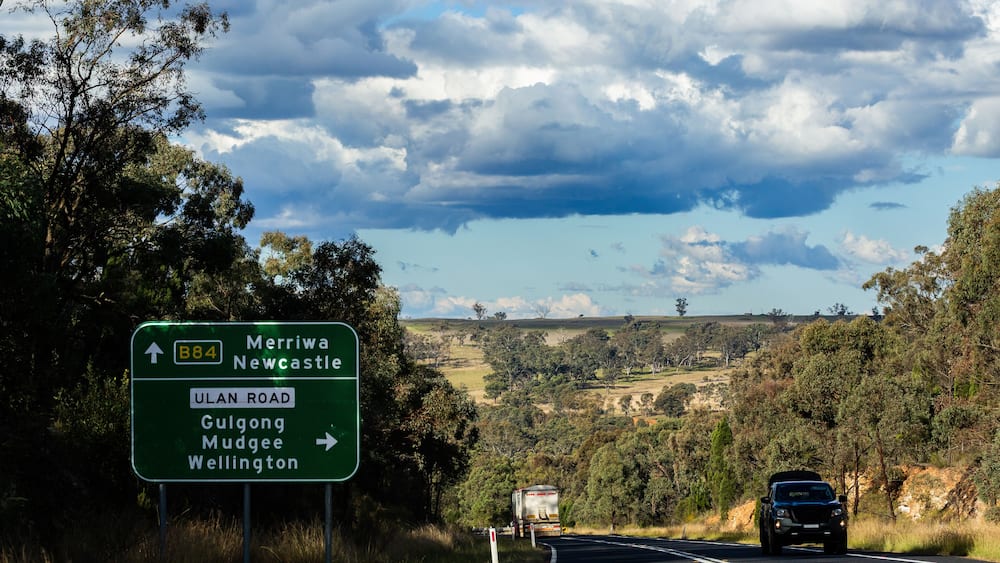 Green roadside sign with directions on B84 and Ulan Road on trip down Australian highway
