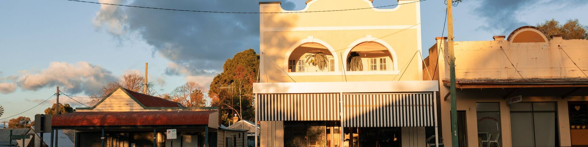 View over low brick fence of historic buildings along quiet street in Australia