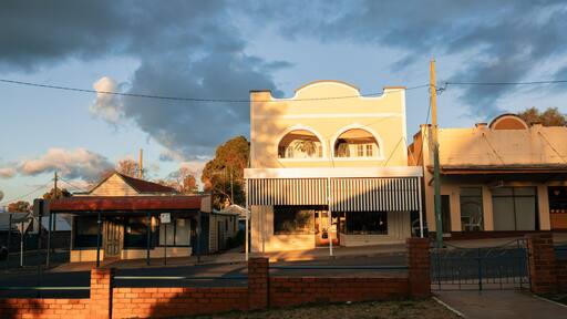 View over low brick fence of historic buildings along quiet street in Australia