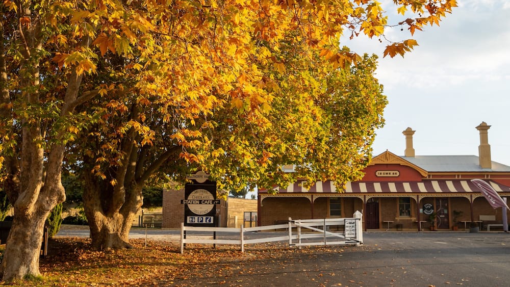 A vintage train station with a sign for the Milthorpe Railway Station Cafe.