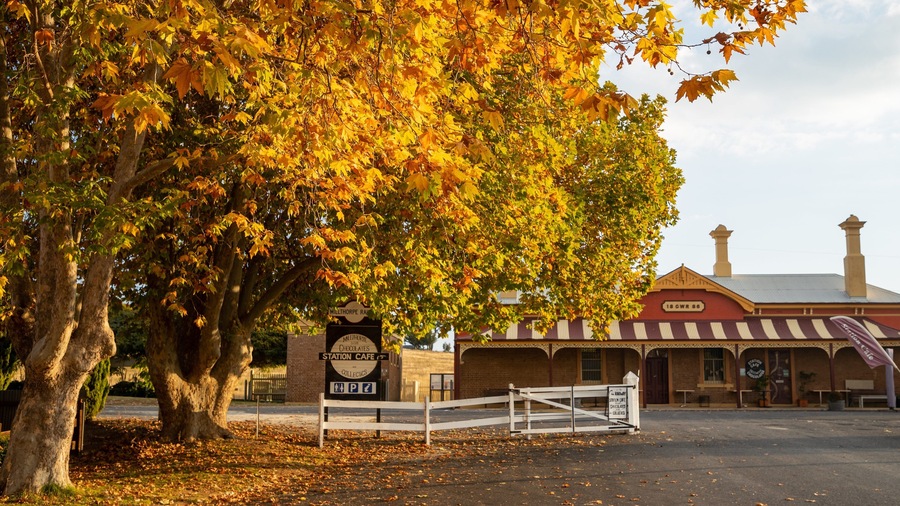 A vintage train station with a sign for the Milthorpe Railway Station Cafe.