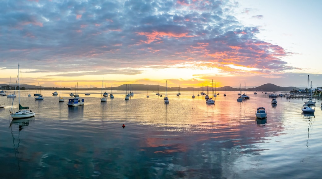 Aerial sunrise waterscape with boats, clouds and reflections