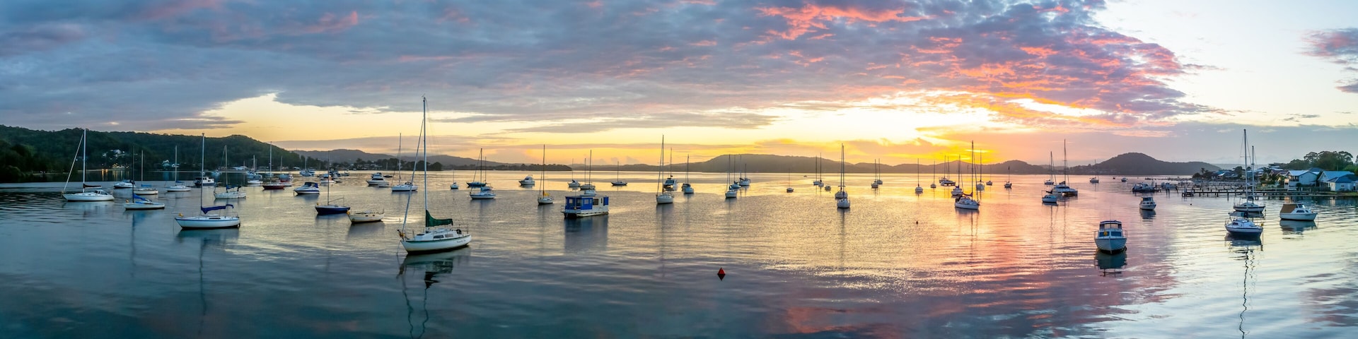 Aerial sunrise waterscape with boats, clouds and reflections