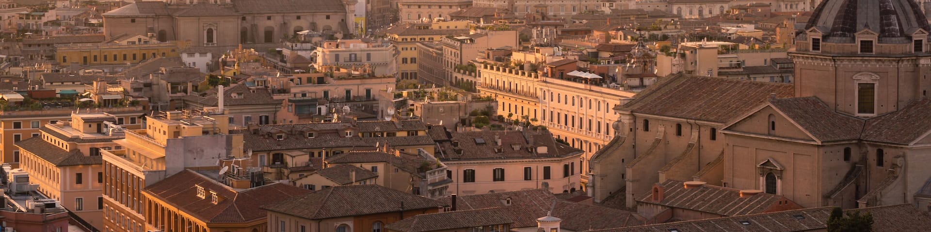 Panorama of Rome with the Dome of St. Peter's Basilica and the the Vatican City in golden Light at sunset.