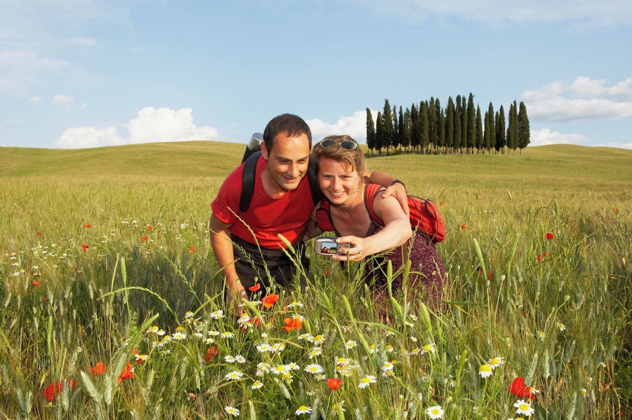 Italy, Tuscany, Crete Senesi, couple photographing themselves in field