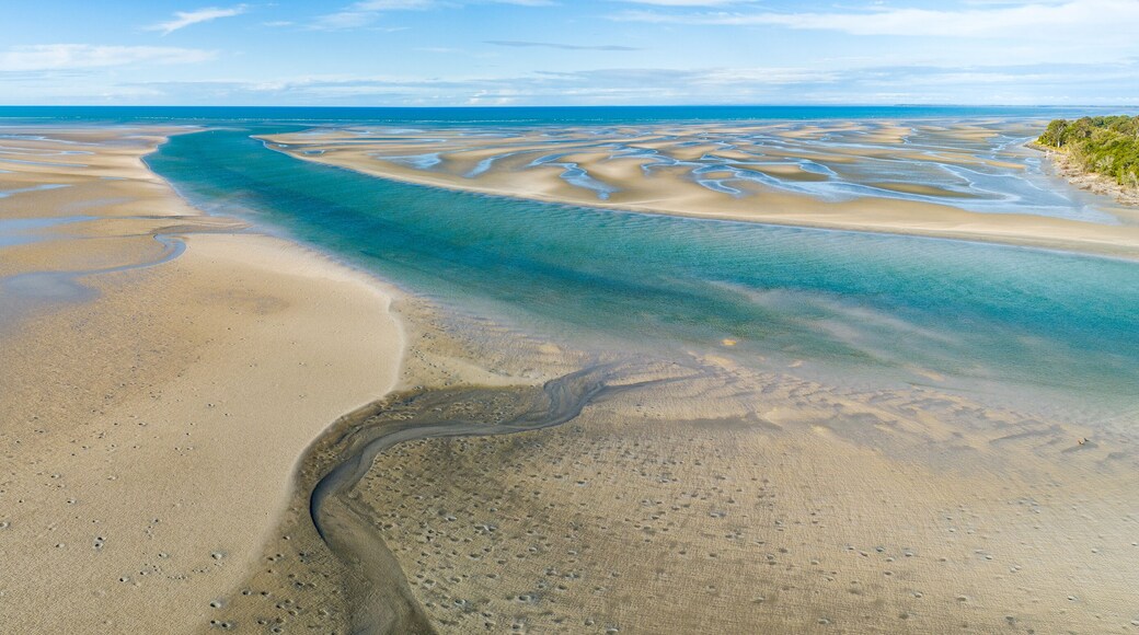 Panorama of coastline with ripples and patterns in the sand.