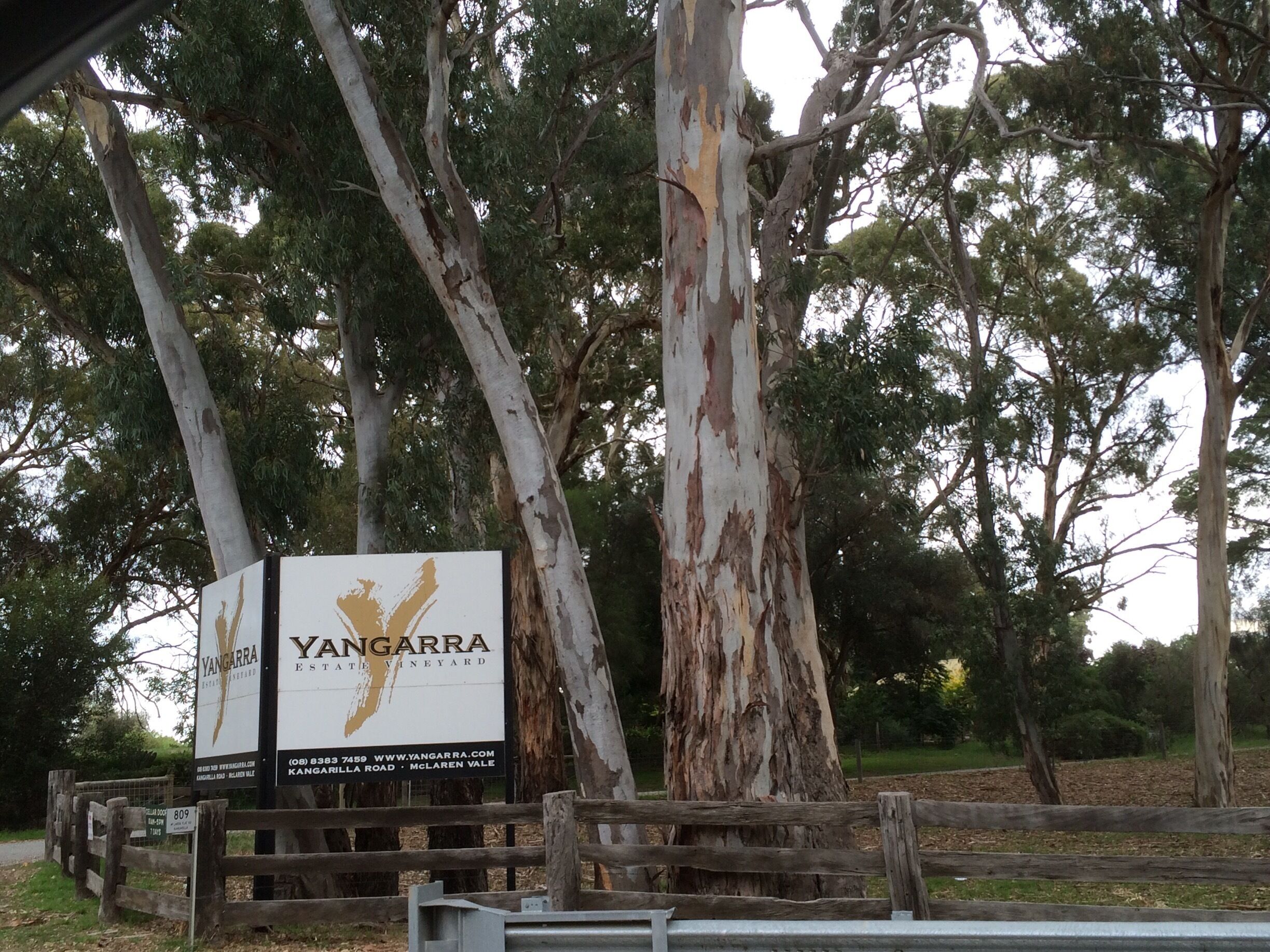 A sign for Yangarra Estate Vineyard with a wooden fence and eucalyptus trees in the background.