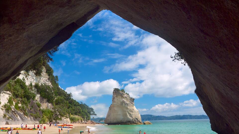 A beach with a large rock formation in the background.