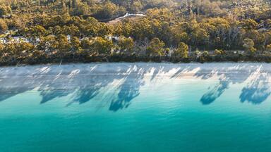 Drone Birdseye view of Adventure Bay, Tasmania, Australia. Blue water with shadows during sunset. Beautiful beach and travel concept.