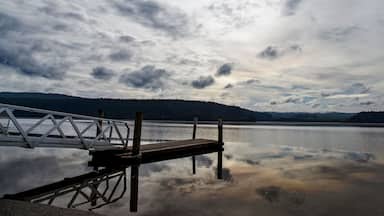 Lake Maraetai in Mangakino, Waikato district, New Zealand. Still waters, small boat jetty, reflections of cloud and sky. Moody, peaceful, reflective. Hydroelectric station, recreational activities.