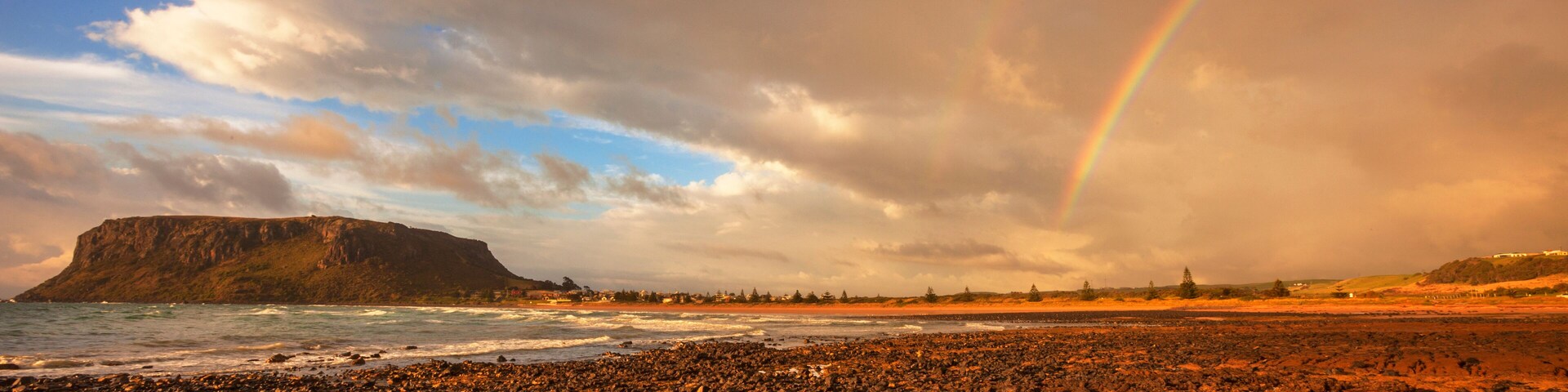 Scenic ,rainbow ,over Ogilvey Beach, Stanley. The Nut a volcanic plug in the distance. North West Coast of Tasmania, Australia.