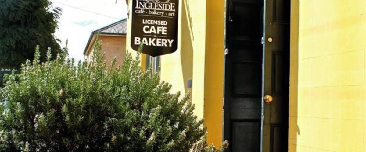 A yellow building with a sign for Ingleside Cafe & Bakery.