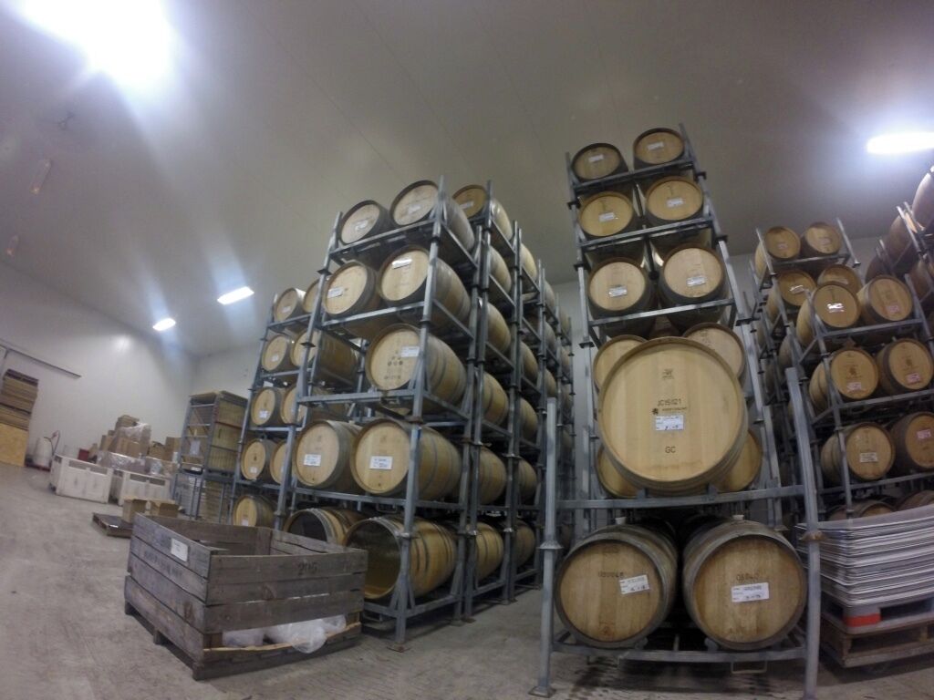 Stacks of wooden barrels in a warehouse.
