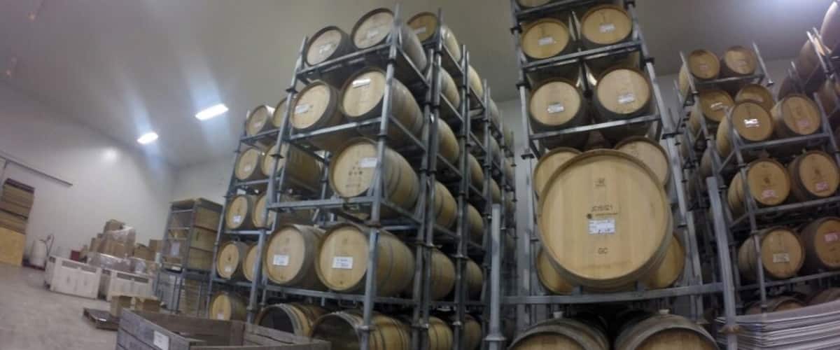 Stacks of wooden barrels in a warehouse.