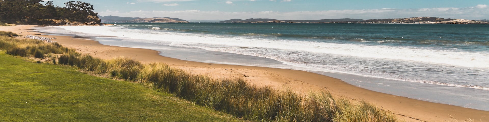 Bllackmans Bay beach in southern Hobart in Tasmania, Australia on a very windy day with intense swell and waves and no people