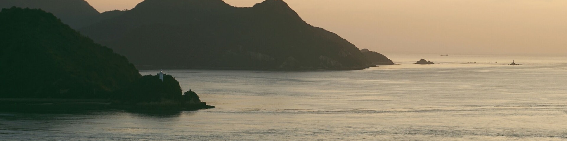 A coastal landscape with mountains and calm sea.