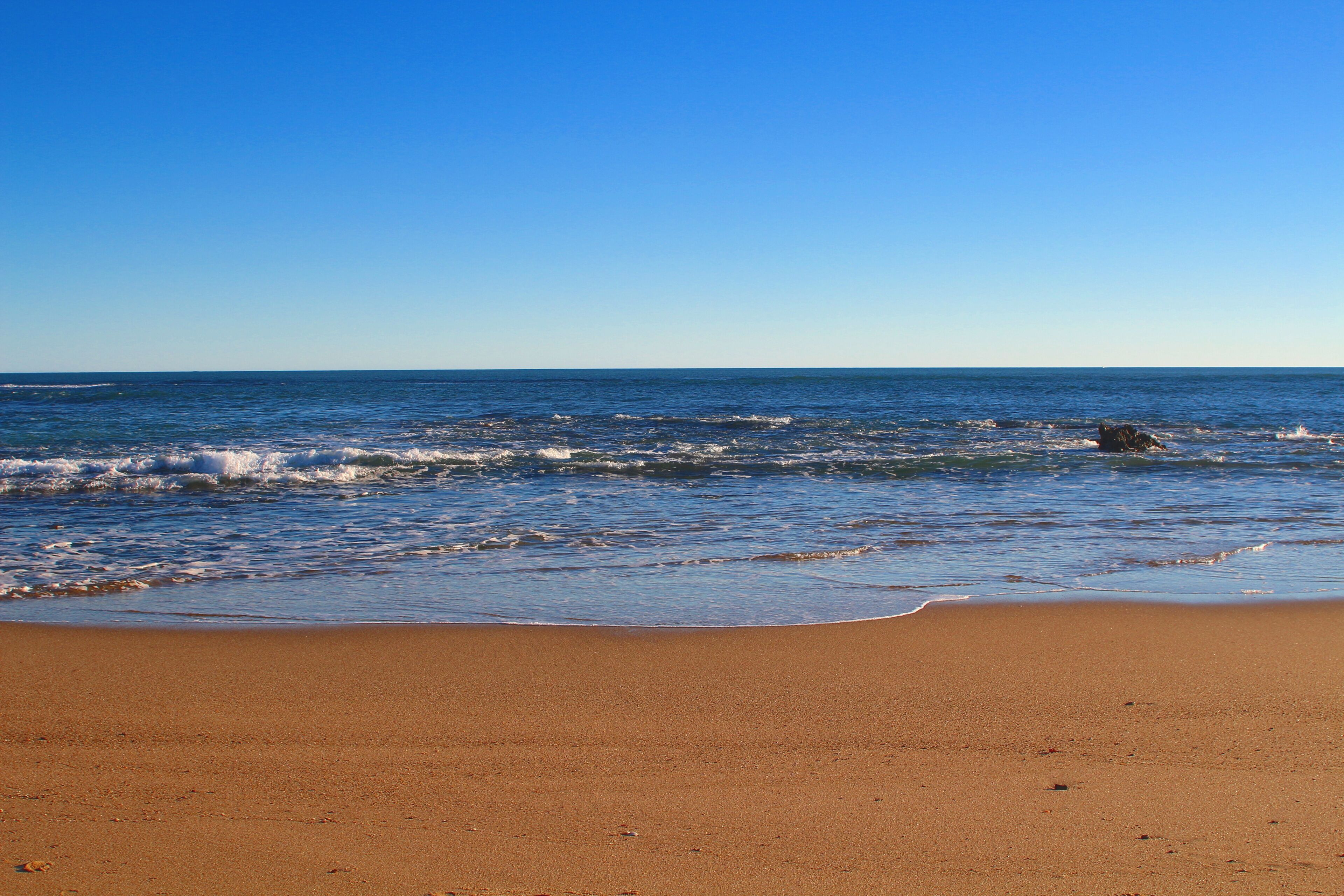 Golden sand beach, blue ocean and sky background - Port Denison, Western Australia
