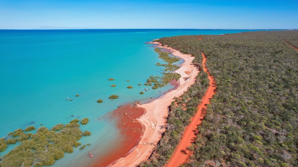 Aerial view of red sand beach and turquoise water in Roebuck Bay, Kimberley Region, Australia.