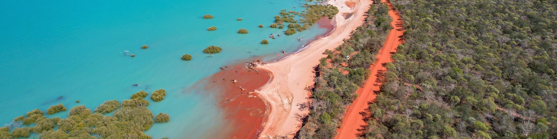 Aerial view of red sand beach and turquoise water in Roebuck Bay, Kimberley Region, Australia.