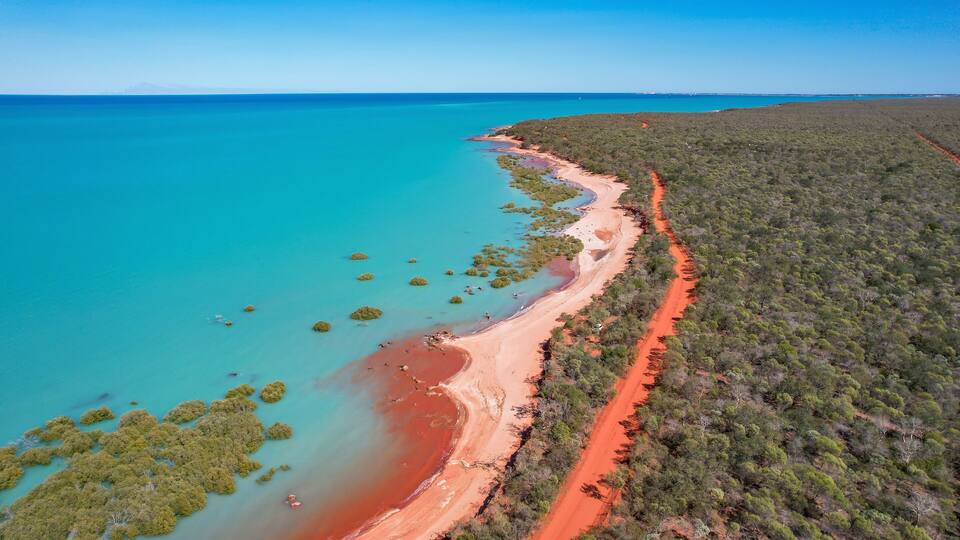 Aerial view of red sand beach and turquoise water in Roebuck Bay, Kimberley Region, Australia.