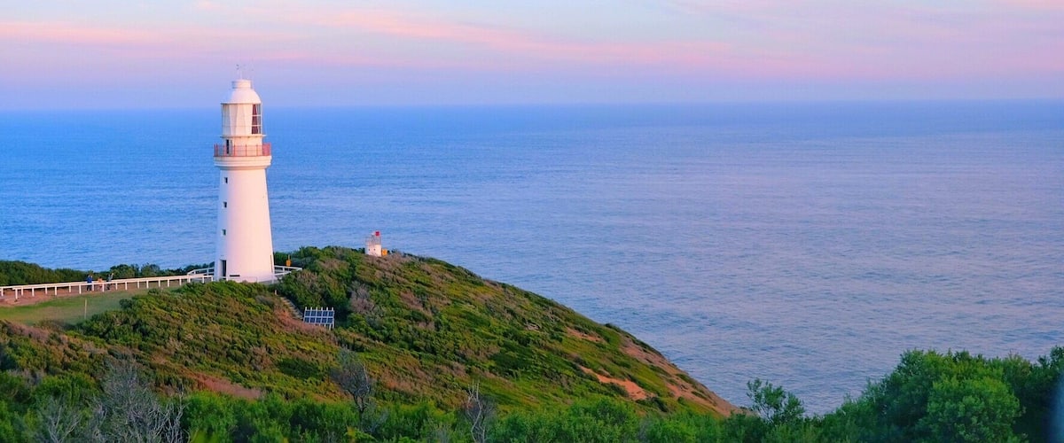 Lighthouse under setting sun.