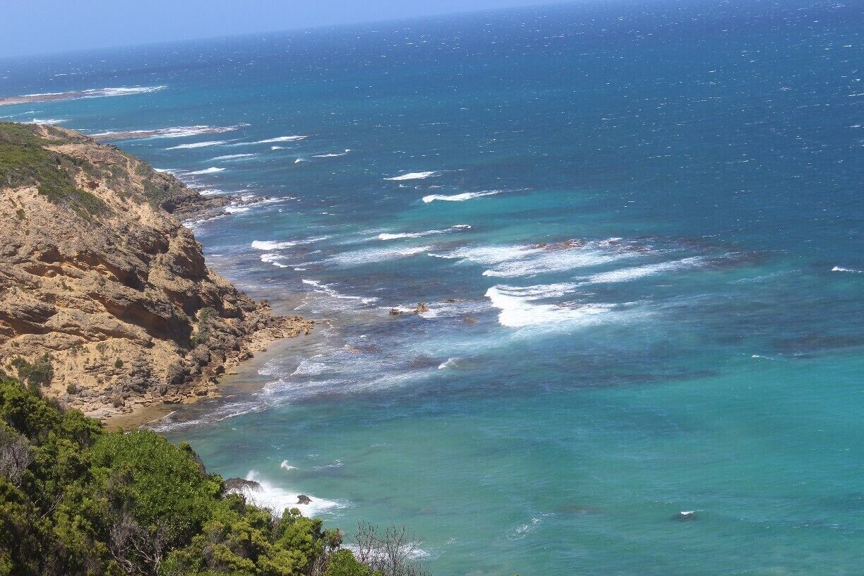 A coastal landscape with rocky cliffs and turquoise waters.
